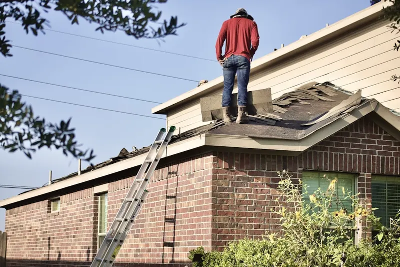 Professional roofer working on a residential roof in Brinckerhoff